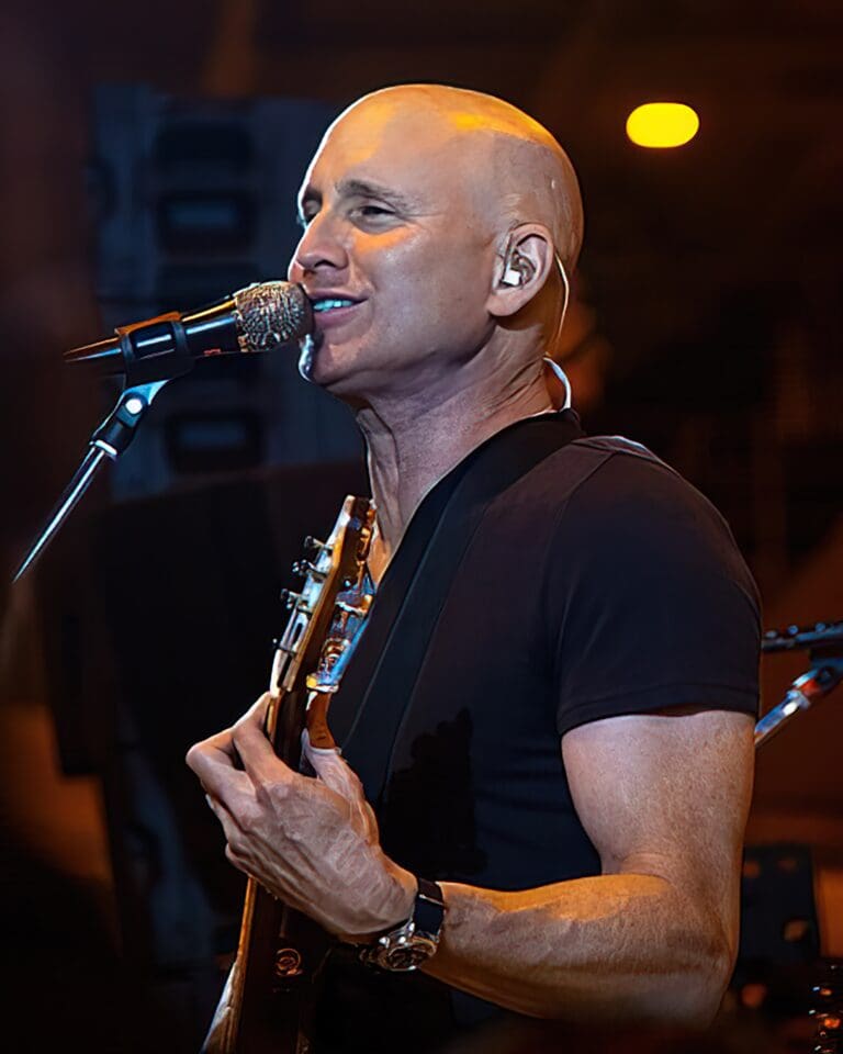 Matt Scannell, lead singer of Vertical Horizon, plays a guitar and sings into microphone at concert.